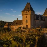 Château de la grande filolie dordogne : vue extérieure avec lauzes et mâchicoulis, golden hour