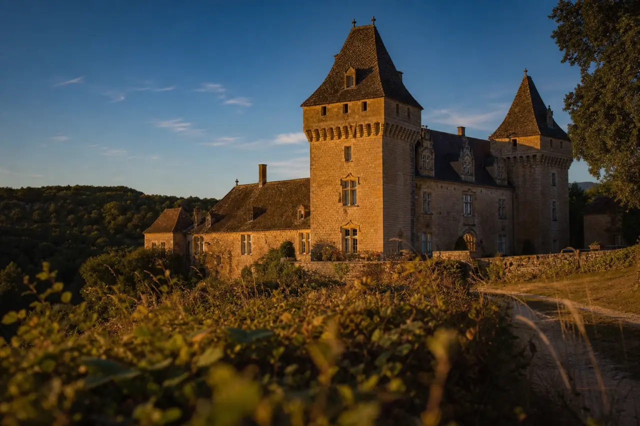Château de la grande filolie dordogne : vue extérieure avec lauzes et mâchicoulis, golden hour